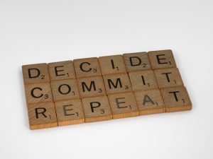 scrabble tiles that spell out "Decide" "Commit" and "Repeat"