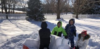 4 kids building a snow fort