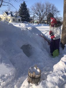 girl digging a tunnel in the snow