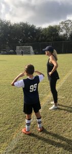 boy and female soccer coach on the sidelines 