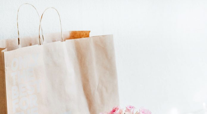 gift bag with pink roses in a white too,m