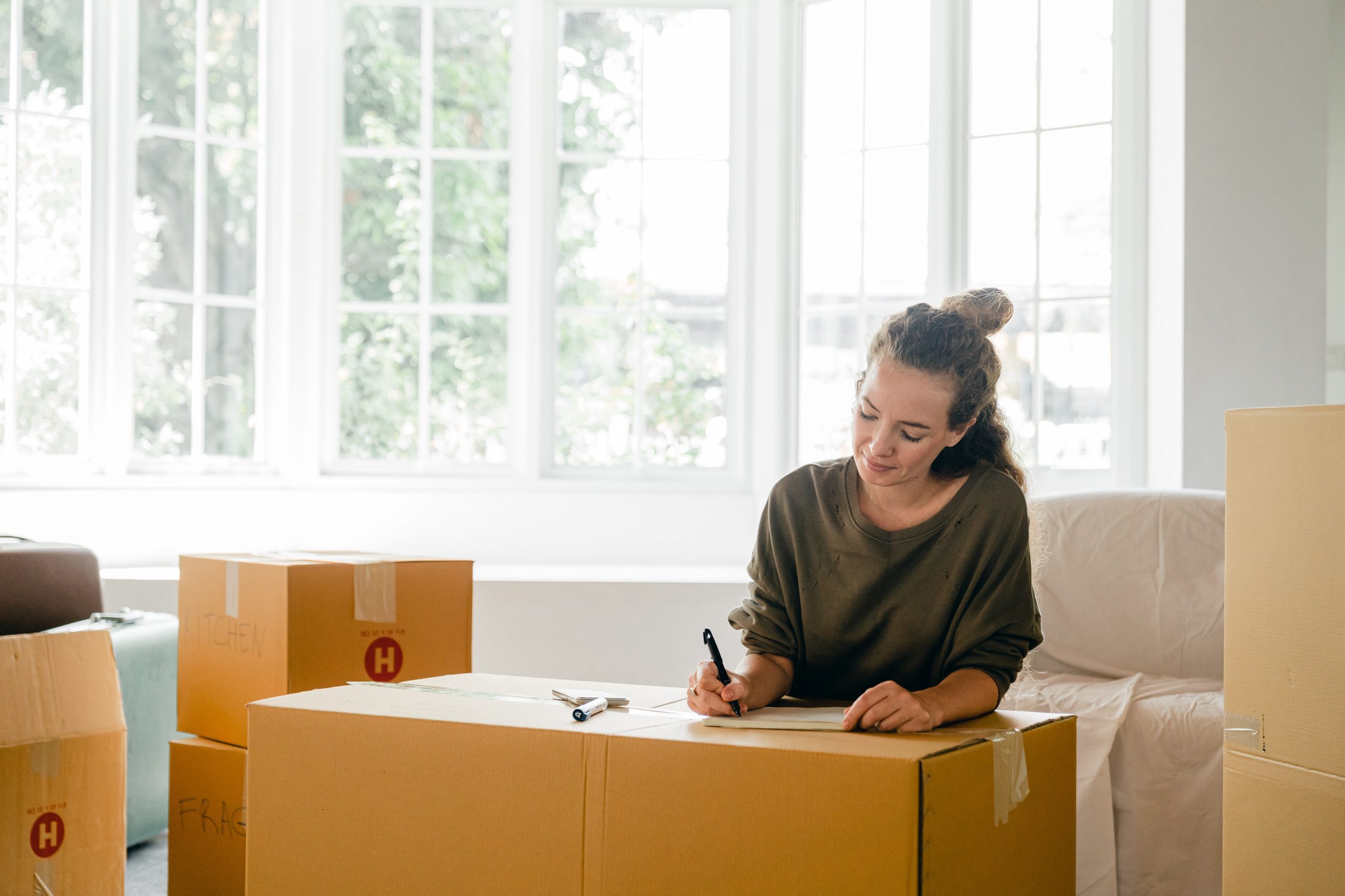 woman writing on a moving box