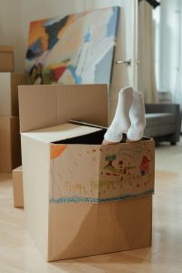 child in a moving box with their feet poking out