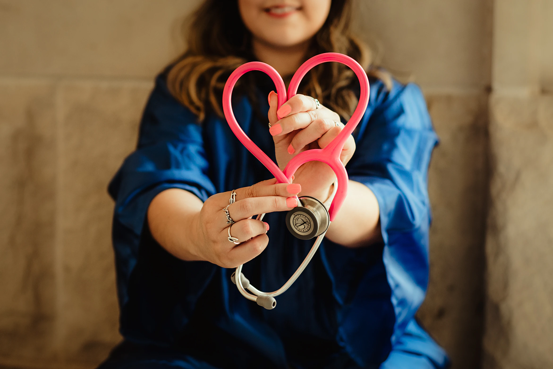 woman holding a red stethoscope in a heart shape