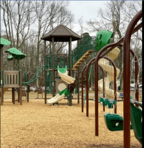 green and brown playground with multiple slides