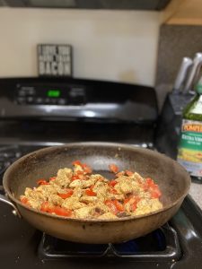 sautéed chicken and tomatoes in a pan on the stove 