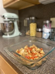 sautéed chicken and tomatoes in a baking dish on the kitchen counter