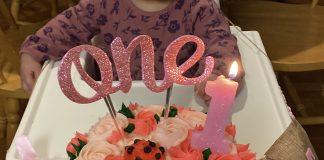 Birthday cake with 1 candle and the word one.