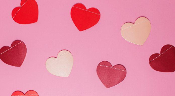 cut out hearts, which are different shades of pink and red, are shown against a light pink background.
